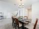 Dining area featuring a modern chandelier, a dining table set for six, and stylish wood-look tile flooring at 8886 Fallen Oak Dr, Davenport, FL 33896