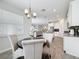 Bright dining area featuring a modern chandelier, round table, and open access to the contemporary kitchen at 8886 Fallen Oak Dr, Davenport, FL 33896