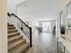 Inviting foyer with wood-look tile flooring, a staircase with iron railings, and an open view into the living and dining areas at 8886 Fallen Oak Dr, Davenport, FL 33896