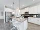 Stylish kitchen showcases white cabinets, stainless steel appliances, a center island, and sleek countertops at 8886 Fallen Oak Dr, Davenport, FL 33896
