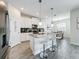 Modern kitchen features white cabinetry, stainless steel appliances, pendant lighting and a breakfast bar with seating at 8886 Fallen Oak Dr, Davenport, FL 33896