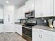 Bright kitchen featuring stainless steel appliances, white cabinets, sleek countertops, and modern finishes at 8886 Fallen Oak Dr, Davenport, FL 33896