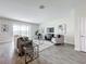 Bright living room featuring wood-style flooring, a plush sofa, and an oversized window with views at 8886 Fallen Oak Dr, Davenport, FL 33896