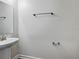 Simple half-bathroom featuring a pedestal sink, a mirror, and modern fixtures in a neutral color palette at 8886 Fallen Oak Dr, Davenport, FL 33896
