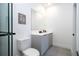 Bathroom with gray vanity, white toilet and large mirror at 9029 Ibiza Ln # 1, Kissimmee, FL 34747