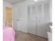 Bedroom with a pink bedspread and large closet with louvered doors at 905 Suwannee Dr, Apopka, FL 32703