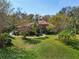 Single-story home with red tile roof, palm trees and well-manicured lawn at 10 Broadwater Dr, Ormond Beach, FL 32174