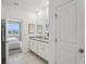 Main bathroom with double vanity and view of bedroom at 10140 Huntingnet Way, Leesburg, FL 34748