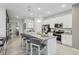 Modern kitchen with island and view into living room at 10140 Huntingnet Way, Leesburg, FL 34748