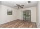 Bright bedroom with wood-look floors and sliding glass door to patio at 11431 Nw 100Th St, Ocala, FL 34482