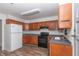 Kitchen with wood cabinets, black appliances, and vinyl flooring at 11431 Nw 100Th St, Ocala, FL 34482