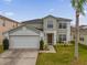 Two-story house with a green exterior, two-car garage, and landscaping at 1255 Blackwater Pond Dr, Orlando, FL 32828