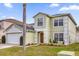 Two-story house with a green exterior, two-car garage, and landscaping at 1255 Blackwater Pond Dr, Orlando, FL 32828