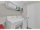 Laundry room features white washer and dryer, and overhead shelving at 1255 Blackwater Pond Dr, Orlando, FL 32828