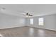 Spacious bedroom featuring hardwood floors, ceiling fan and natural light from two windows at 15199 Sugargrove Way, Orlando, FL 32828