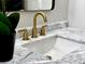 Close-up of a bathroom vanity with gold fixtures and marble countertop at 1933 Winnebago Trl, Fern Park, FL 32730