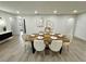 Bright dining room with wood table and six chairs, hardwood floors, and modern art at 1933 Winnebago Trl, Fern Park, FL 32730