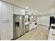 White kitchen with stainless steel refrigerator and light wood flooring at 1933 Winnebago Trl, Fern Park, FL 32730