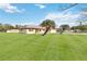 House with a large grassy yard and palm trees at 2643 Borinquen Dr, Kissimmee, FL 34744