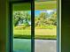 View of backyard through sliding glass doors; green grass and trees at 2645 Sw 155Th Ln, Ocala, FL 34473