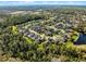 Expansive aerial view of a residential neighborhood nestled among lush green trees and landscaping near a pond at 3063 Juneberry Ter, Oviedo, FL 32766