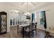 Formal dining room with glass-top table, chandelier, and hardwood flooring at 3063 Juneberry Ter, Oviedo, FL 32766