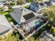 Aerial view of a sparkling pool with a spa, screened-in enclosure, and solar panels at 3063 Juneberry Ter, Oviedo, FL 32766