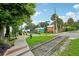 Residential street view with train tracks, lush landscaping, and colorful houses at 33431 Seattle Slew Dr, Sorrento, FL 32776