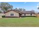 Tan house with white shutters, lush lawn, and landscaping at 4960 Se 37Th Ct, Ocala, FL 34480