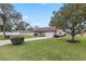 Tan house with attached garage, manicured lawn, and landscaping at 4960 Se 37Th Ct, Ocala, FL 34480