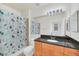 Clean bathroom with light wood cabinets, black countertop, and shower/tub at 501 Mirasol Cir # 306, Celebration, FL 34747