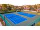 Aerial shot showcases meticulously maintained blue tennis courts, bordered by trees and green fencing at 5368 Elm Ct # 354, Orlando, FL 32811