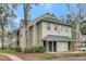 Two-story condo exterior with green siding, a covered entrance, and lush landscaping around the building at 6034 Westgate Dr # 202, Orlando, FL 32835