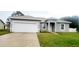 Gray house with a white garage door and a well-maintained lawn at 615 N Delmonte Ct, Kissimmee, FL 34758