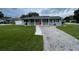 Cute ranch home with red door, landscaped lawn, and a gravel driveway at 6642 Matchett Rd, Orlando, FL 32809