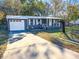 Gray house with white garage door and landscaped yard at 6952 Sw 85Th Pl, Ocala, FL 34476