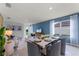 Bright dining area with a white table and gray chairs, adjacent to living room at 7061 Carib Grackle Dr, St Cloud, FL 34773