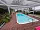 Inviting rectangular pool with brick patio and covered lanai at 824 Lake Elbert Ct, Winter Haven, FL 33881