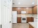 Modern kitchen with wood cabinets and white appliances at 8276 Maritime Flag St # 201, Windermere, FL 34786