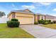 One-story house with a yellow exterior, a two-car garage, and well-manicured landscaping at 841 Greenshank Dr, Haines City, FL 33844