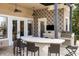 Covered outdoor kitchen with bar seating and grill at 9213 Foxhall Ct, Orlando, FL 32819