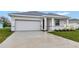 Front view of a newly built home with a two-car garage and well-manicured lawn at 925 Magnolia Ave, Holly Hill, FL 32117