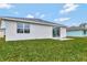 Rear view of house, showcasing sliding glass doors and grassy yard at 925 Magnolia Ave, Holly Hill, FL 32117