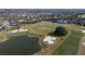 Aerial view of a golf course community with houses and a pond at 9544 Starling Loop, Leesburg, FL 34788