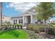 One-story home with gray siding, covered porch, and lush landscaping at 9544 Starling Loop, Leesburg, FL 34788