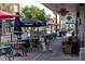 Outdoor seating area with tables, umbrellas, and a person with a dog at 9544 Starling Loop, Leesburg, FL 34788