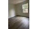 Bright bedroom with wood-look floors and large window at 9868 6Th Ave, Orlando, FL 32824