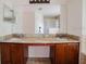 Bathroom vanity with double sinks, wood cabinets, granite countertops, and mirror at 1010 Embrun Ct, Kissimmee, FL 34759
