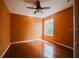Bedroom with wood floors, neutral walls, a window, and a ceiling fan at 1010 Embrun Ct, Kissimmee, FL 34759
