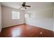 Loft area with wood floors, a large window, and a view of the staircase at 1010 Embrun Ct, Kissimmee, FL 34759